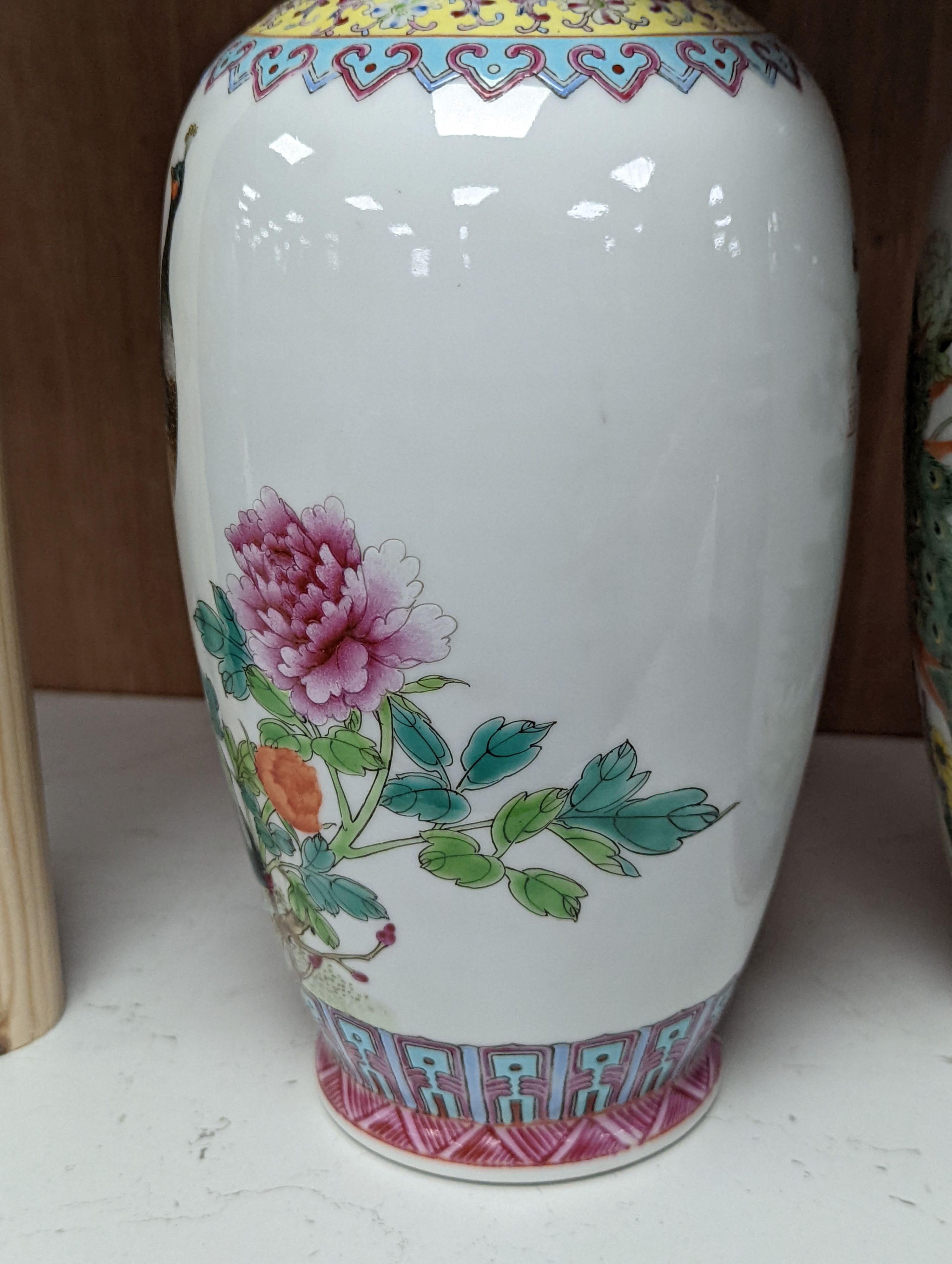 A pair of Chinese famille rose vases decorated with peacocks, 31cm